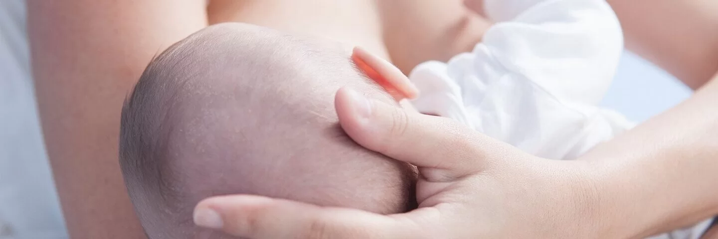 Eine Mutter hält ihr Baby im Arm und stillt es. 