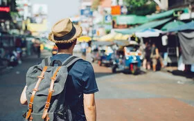 Ein junger Mann mit Rucksack auf einem asiatischen Markt