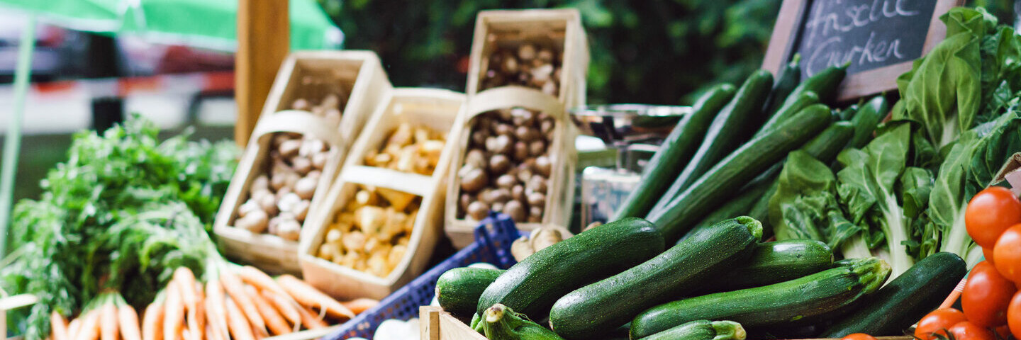 Blick auf einen Marktstand mit Gemüse.