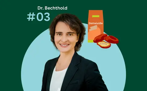 Dr. Angela Bechthold steht vor einem grünen Hintergrund. Rechtes daneben sind eine orangefarbene Verpackung mit der Aufschrift Dattelsüße und mehrere halbierte Datteln zu sehen.