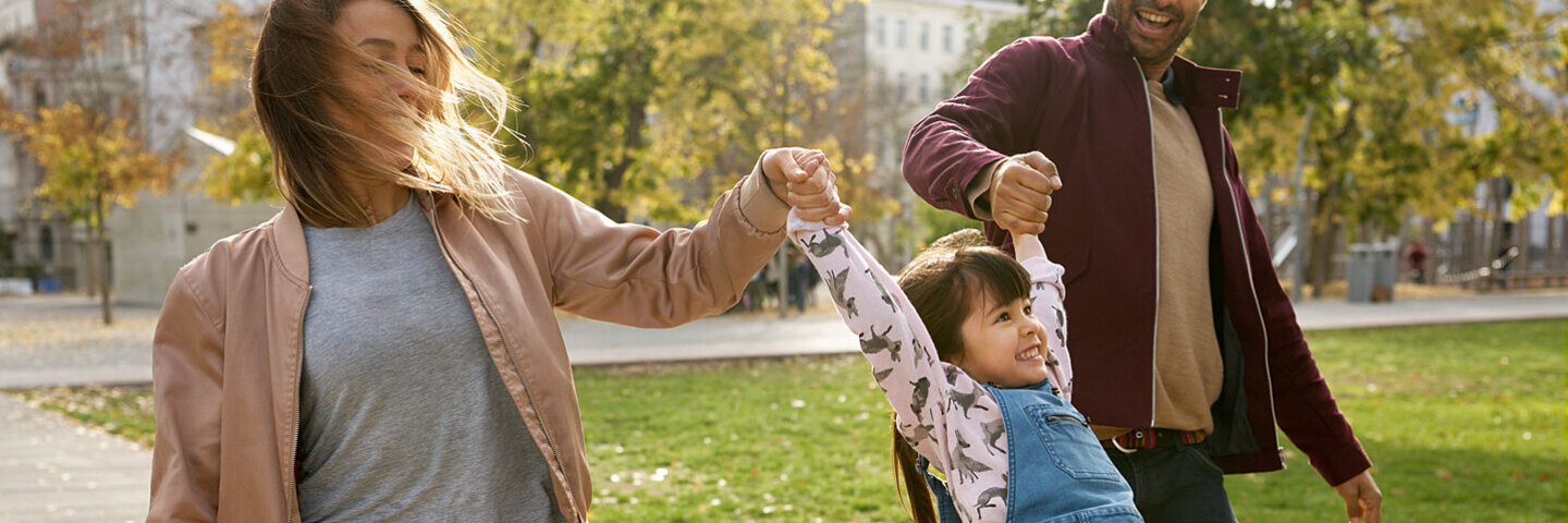 Eltern genießen Familienzeit mit ihrem Kind an der frischen Luft, damit die Coronakrise den Alltag nicht überschattet.