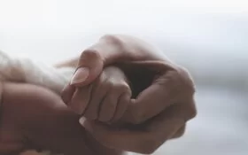Mutter hält Neugeborenes im Arm