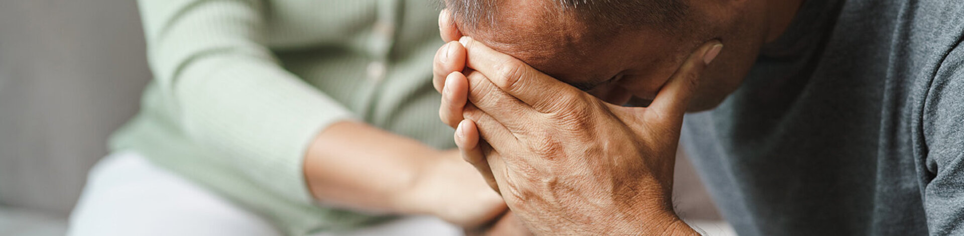 Ein nachdenklich wirkender, junger Mann sitzt auf einer Bank. Der Familiencoach Depression hilft dabei, den Alltag mit einem depressiv erkrankten Menschen besser zu bewältigen.