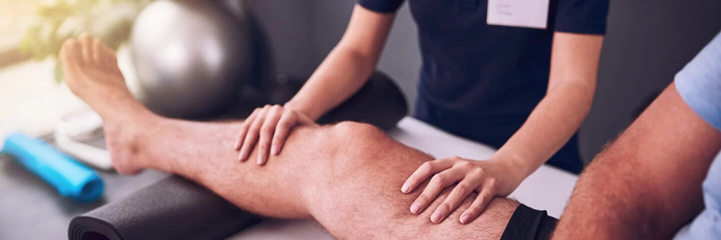 Eine Physiotherapeutin behandelt einen Arthrose-Patienten.