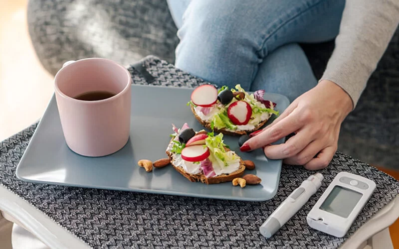 Eine junge Diabetikerin isst genussvoll Frühstück.