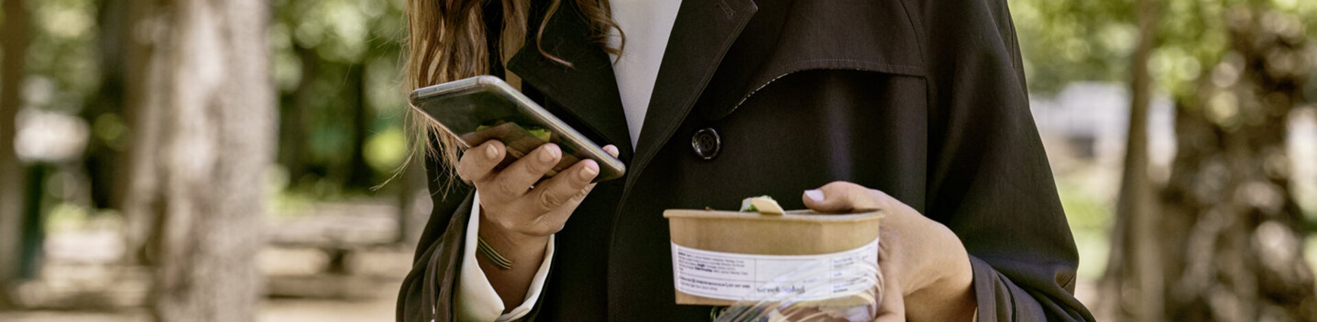 Eine junge Frau liest Nachrichten auf dem Smartphone. Mit dem AOK-Newsletter ist sie bestens informiert.