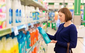 Eine Frau sucht im Supermarkt nach einem Waschmittel, das keine Allergie auslöst.