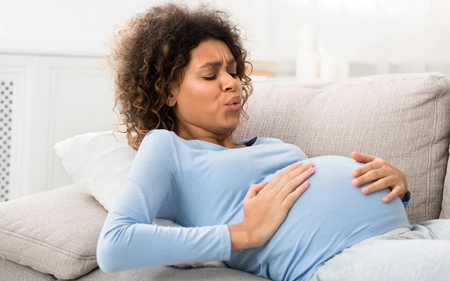 Eine Frau ist zu Hause und bekommt Wehen, die Geburt steht an.