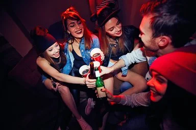 Gruppe junger Menschen beim Binge-Drinking.