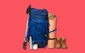 Zwei Wanderstöcke angelehnt an einen Rucksack, daneben stehen eine aufgerollte Matte und zwei Wanderstiefel.