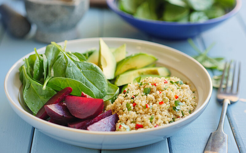 Gesunde Quinoa-Bowl mit Spinat, Avocado und Rote Beete.