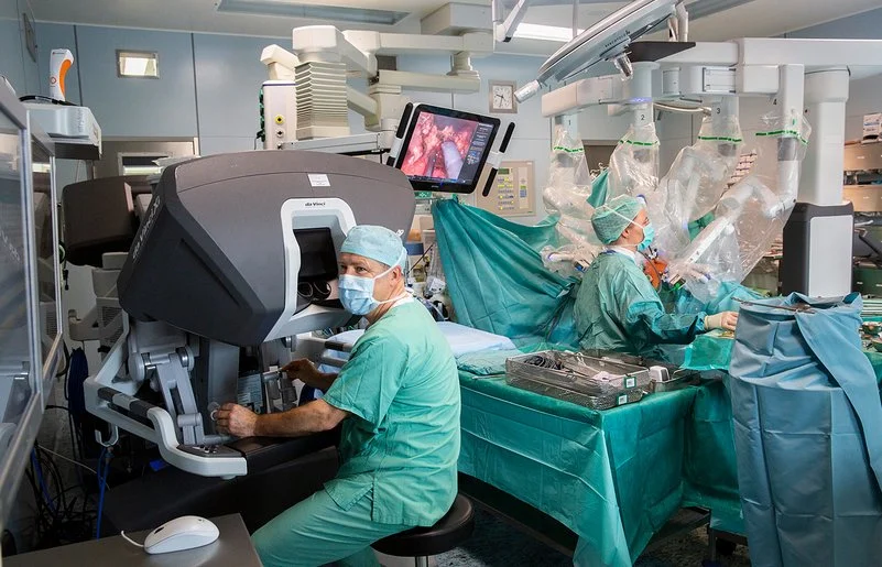 In einem Operationssaal des Universitätsklinikums Leipzig wird eine Operation mit einem Robotersystem durchgeführt. An der Bedienkonsole sitzt Prof. Dr. Jens-Uwe Stolzenburg.