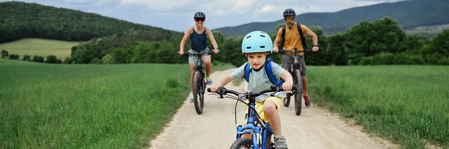 Familie mit kleinem Sohn unternimmt eine Fahrradtour durch Hessen.
