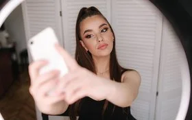Eine junge, gestylte Frau macht ein Selfie.