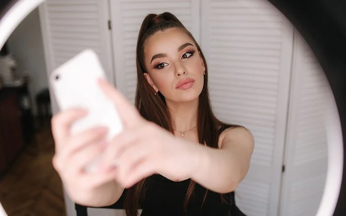 Eine junge, gestylte Frau macht ein Selfie.