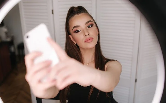 Eine junge, gestylte Frau macht ein Selfie.