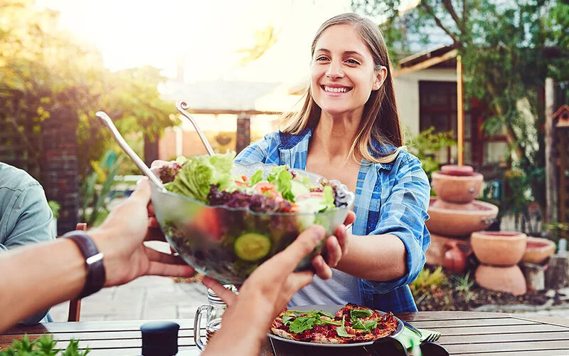 Eine Frau hält eine Schüssel mit gesundem Salat.