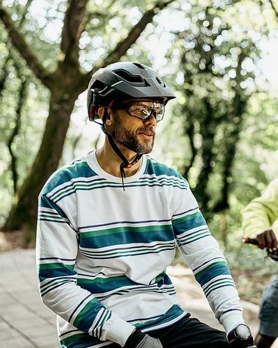Zwei Männer mit Fahrradhelmen stehen mit ihren Fahrrädern auf einem Waldweg.
