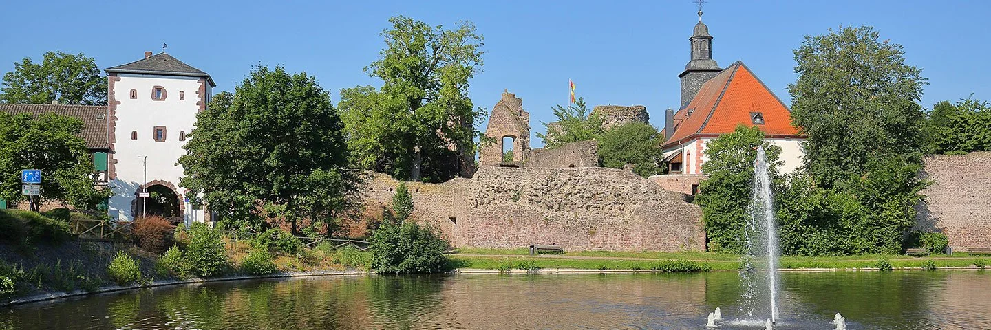 Blick auf den Burgweiher, die Burgkirche sowie die Ruine von Burg Hayn in Dreieichenhain, einem Stadtteil von Dreieich.