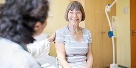 Eine Ärztin berät eine ältere Frau im Krankenhaus. Diese Beratung ist wichtig, da die Behandlung bei Brustkrebs individuell verschieden ist. 