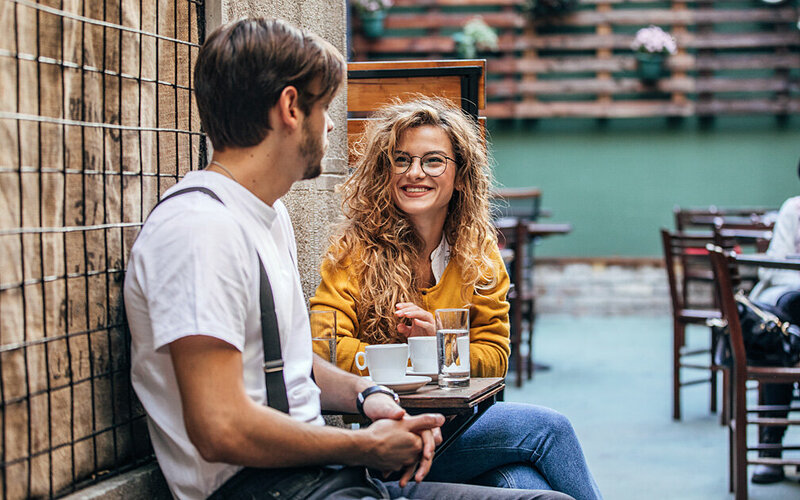 Ein Mann und eine Frau sprechen miteinander in einem Café.