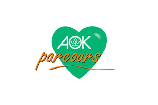 Das Bild zeigt das AOK Parcours Logo. Man sieht ein grünes Herz mit weißem AOK-Schriftzug und das Wort "parcours"in orangenen Buchstaben.