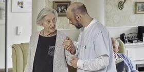 Ältere Dame unterhält sich mit Pfleger