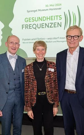 Drei Dozenten im Gruppenbild bei einer Veranstaltung