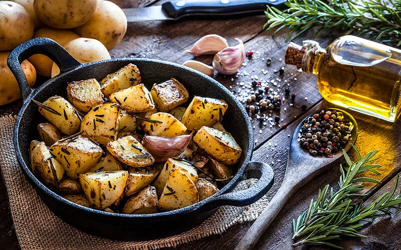 Eine Gusseisenpfanne mit Rosmarin-Kartoffeln.