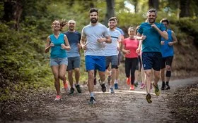 Eine Gruppe Menschen läuft zusammen im Wald.