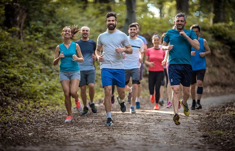 Eine Gruppe Menschen läuft zusammen im Wald.