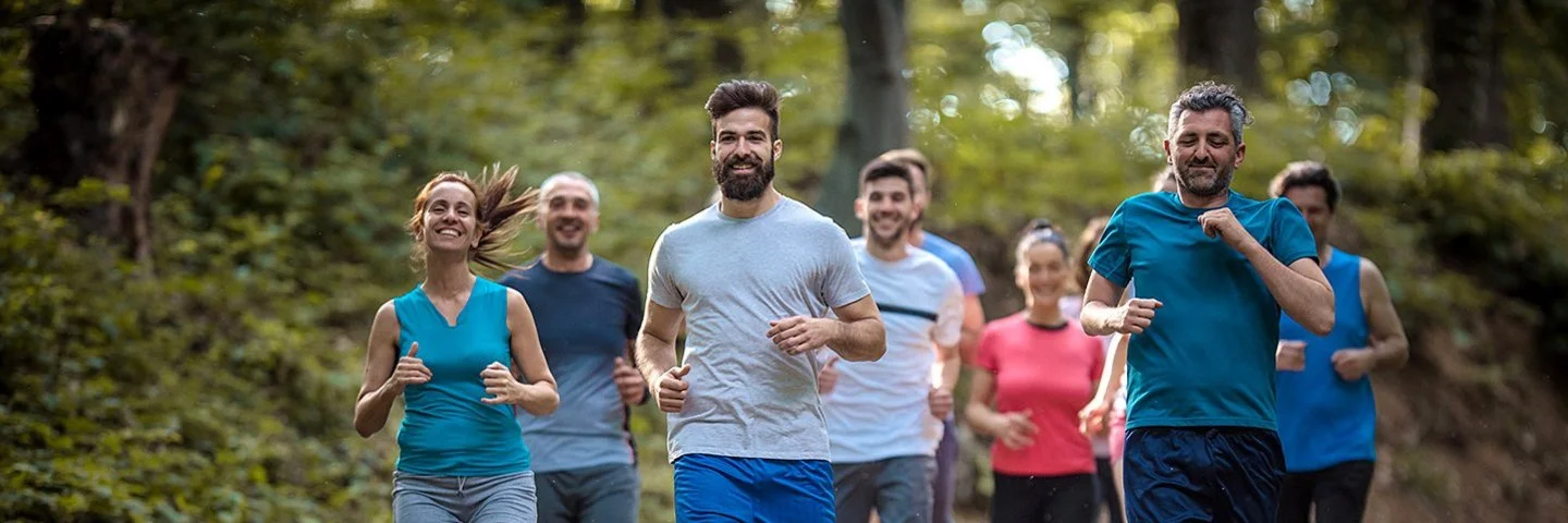 Eine Gruppe Menschen läuft zusammen im Wald.