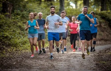 Eine Gruppe Menschen läuft zusammen im Wald.