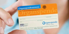 Ein nicht erkennbarer Mann hält einen Organspendeausweis mit der rechten Hand in die Kamera.