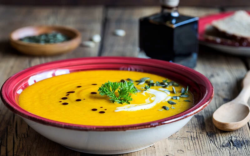 Ein Teller Suppe mit Sanddorn, Kürbis und Karotten.
