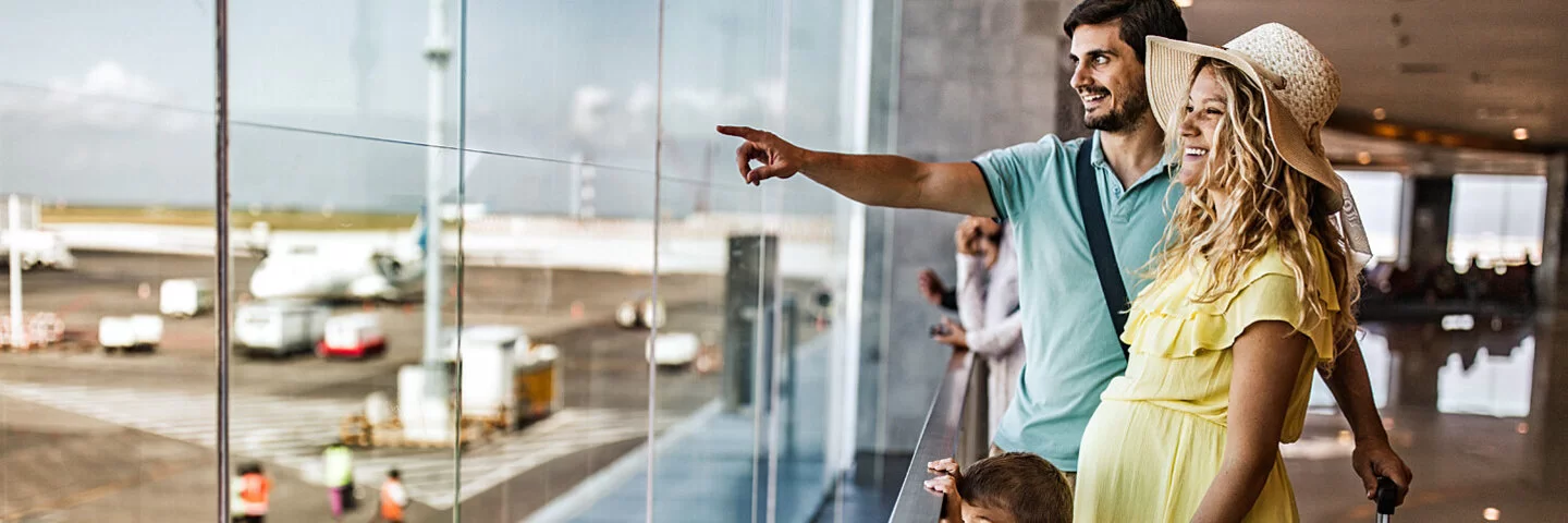 Schwangere Frau mit Ehemann und Kleinkind auf dem Weg zum nächsten Flieger.