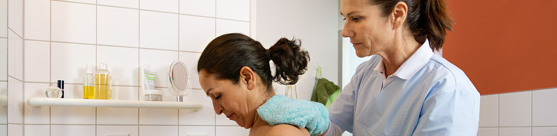 Eine Pflegeperson wäscht eine Patientin zu Hause. Solche Tätigkeiten werden beim Entlassmanagement organisiert.