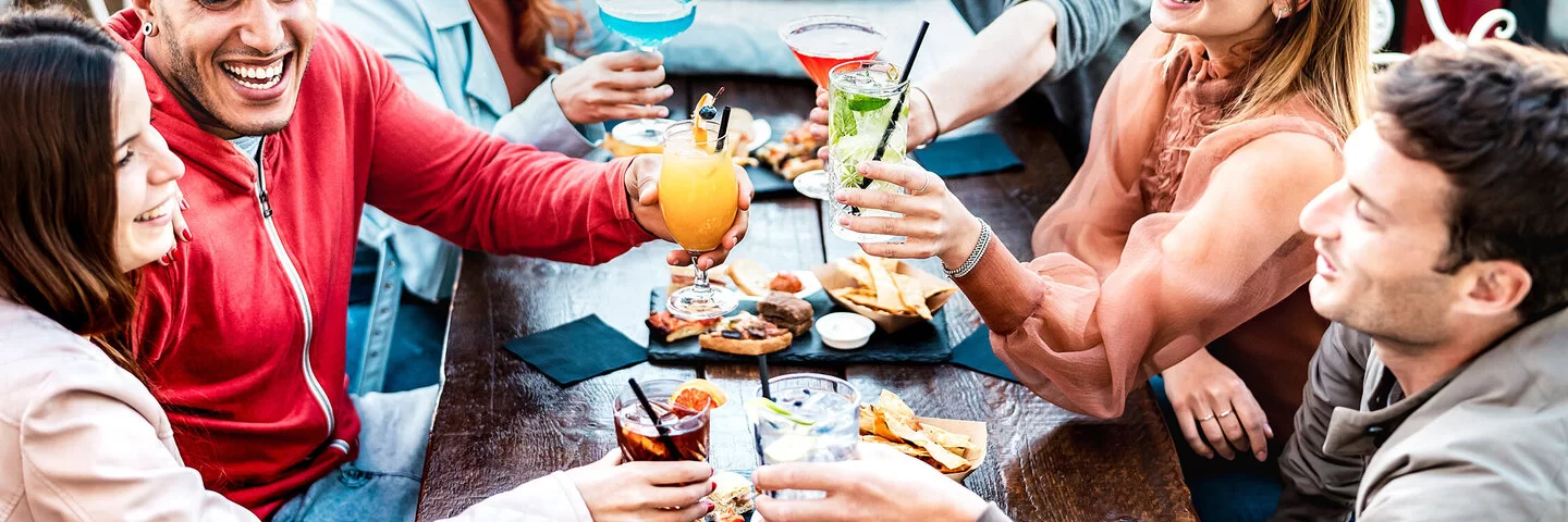 Junge Menschen sitzen und trinken zusammen.