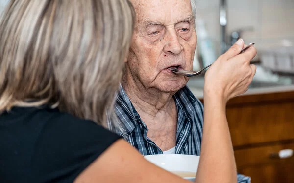 Frau verspürt Scham beim Füttern ihres Vaters.