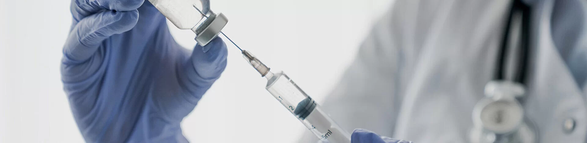 Ein Arzt präpariert eine Spritze mit dem Impfstoff für eine Schutzimpfung.
