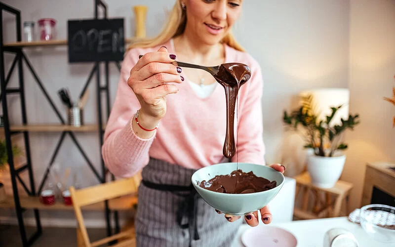 Eine Frau bereitet eine selbstgemachte Nuss-Nougat-Creme zu.