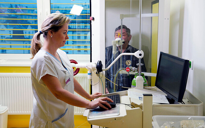 Eine Krankenschwester führt einen Lungenfunktionstest bei einem älterem Mann durch.