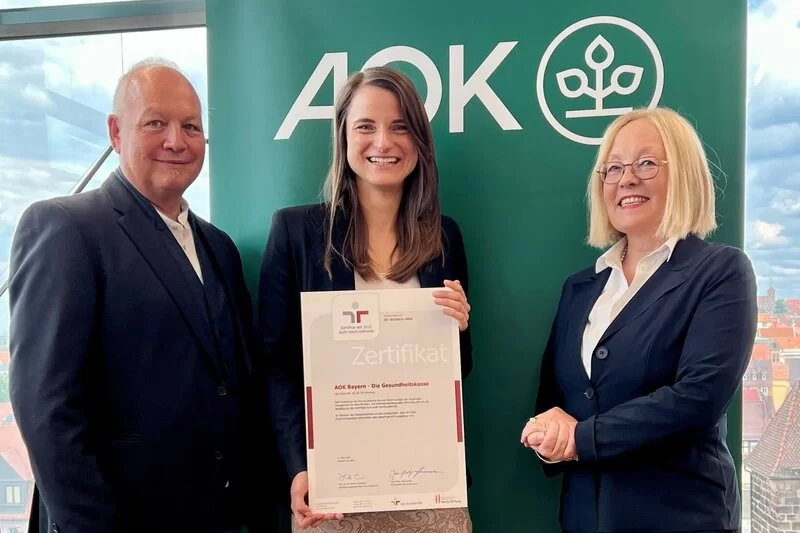 Foto (v.l.): Wolfgang Schraut, Referent Gleichstellung, Familie und Diversity, Christina Gräßel, Geschäftsbereichsleiterin Personal und Dr. Irmgard Stippler, Vorstandsvorsitzende der AOK Bayern, mit dem Zertifikat „audit berufundfamilie“