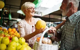 Ältere Frau kauft regional und nachhaltig auf dem Wochenmarkt ein.