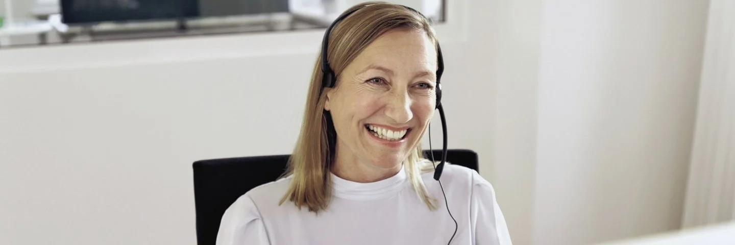 Lächelnde Beraterin im Telefongespräch