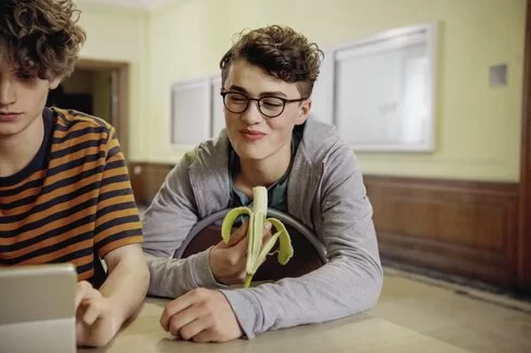Zwei Schüler schauen gemeinsam in einen Laptop
