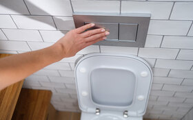 Eine Frau benutzt die Toilettenspülung.