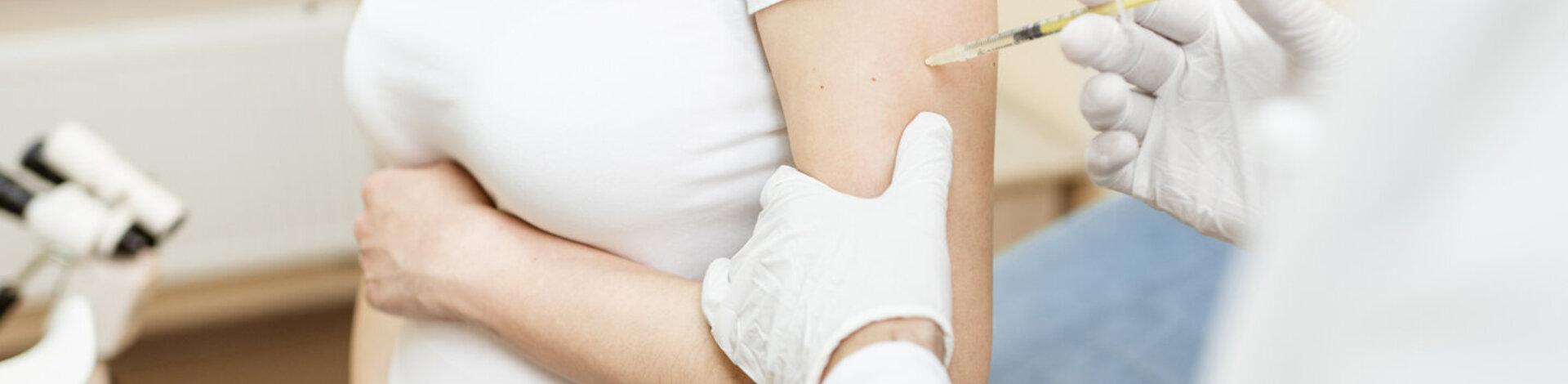 Ein Arzt impft eine schwangere Frau. Werdende Mütter sollten sich gegen Keuchhusten impfen lassen. 