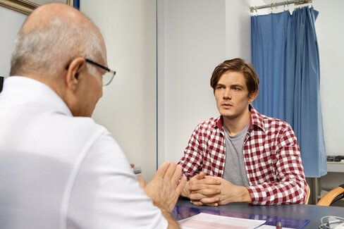 Ein Arzt berät einen Patienten. Die Sterilisation ist eine der sichersten Verhütungsmethoden.
