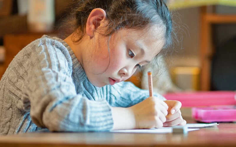 Ein Mädchen lernt und schreibt mit Handschrift.